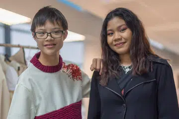 SALING KONGSI IDEA: Cik Nur Rynna Shazrina Mohd Iskandar (kanan) hasilkan kemeja persis baju panas dengan mengambil kira cita rasa belia Sindrom Down, Sijun Leong, yang sukakan kartun Mickey Mouse. Bentuk kartun itu diterapkan pada kocek kemeja. - Foto POLITEKNIK TEMASEK