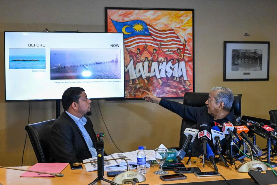 Mantan Perdana Menteri Malaysia, Tun Dr Mahathir Mohamad (kanan), menunjuk ke arah skrin tentang Pedra Branca semasa sidang media di Yayasan Kepimpinan Perdana, Putrajaya pada 10 Disember.