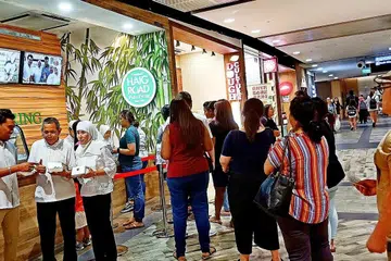 SEMAKIN BERKEMBANG: Encik Hashim (dua dari kiri), Cik Noorzela (tiga dari kiri) dan Encik Razali (kiri) turun padang memantau perniagaan di cawangan terbaru Traditional Haig Road Putu Piring, iaitu yang keenam, di Northpoint City, Yishun.