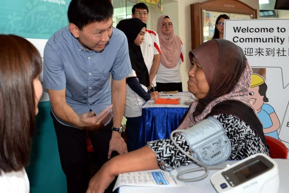 KEMUDAHAN BUAT PENDUDUK: Cik Azizah menjalani pemeriksaan tekanan darah sambil diperhatikan Encik Chee semasa pelancaran enam CHP di Kelab Masyarakat Toa Payoh West semalam. - Foto ZAINAL YAHYA