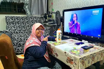 BERI ULASAN SELARI: Cik Siti Aminah Ismail yang membayangkan dirinya persis 'juri' di rumah lengkap dengan susu penaja Gegar Vaganza 7, Farm Fresh, tertarik dengan daya tarikan vokal Mus dan Ayu Damit. - Foto ihsan SITI AMINAH ISMAIL