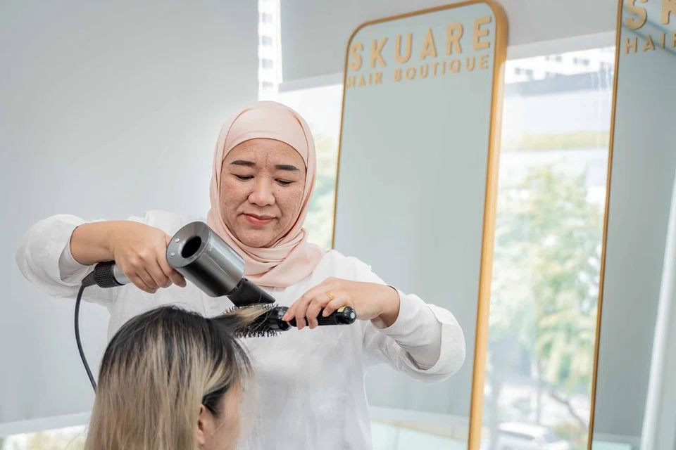 Mengeringkan rambut adalah satu kemestian bagi mereka yang mengenakan tudung, kata Cik Rudzaidah Darsurnik (berdiri).