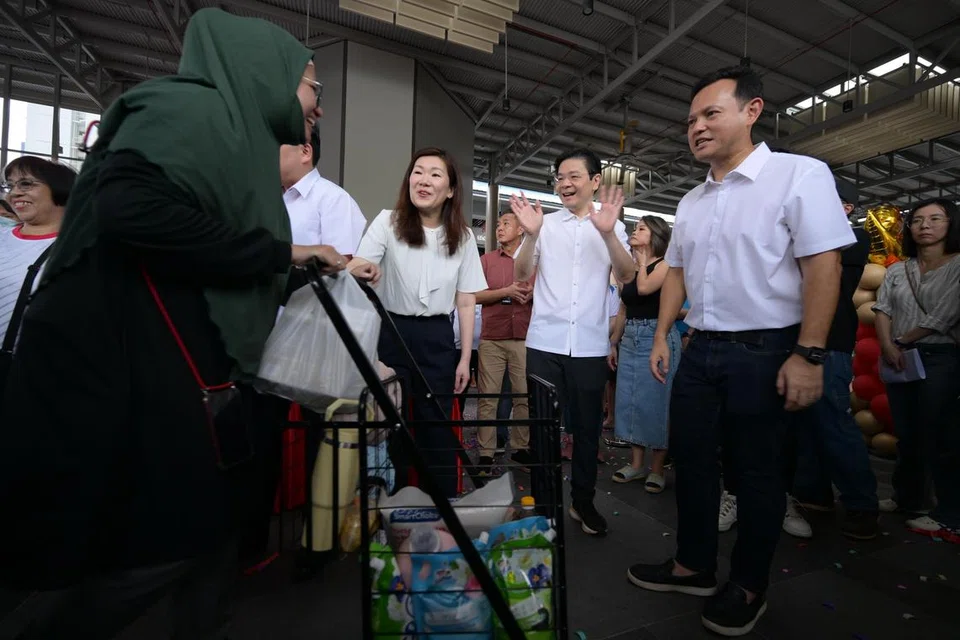 AP GRC Marsiling-Yew Tee (dari kanan) Encik Zaqy Mohamad; Perdana Menteri Lawrence Wong; Cik Hany Soh beramah mesra dengan penduduk GRC Marsiling-Yew Tee yang menerima ‘Tawaran MY $1’. 