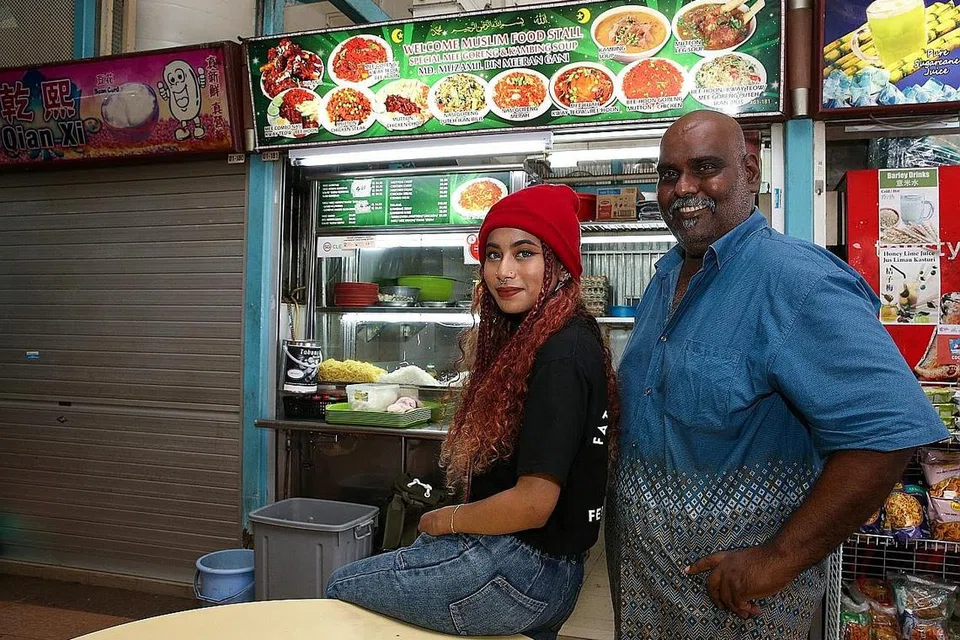 ANAK BAPAK SALING BERI GALAKAN: Penyanyi rap muda Qis, yang baru-baru ini bergelar naib juara dalam peraduan mencipta lagu Raya, 'Ilham: Menjelang Syawal', raih semangat tidak mudah putus asa daripada bapanya, pengendali gerai, Encik Mohamed Muzamil Meeran Gani. - Foto BH oleh YONG LI XUAN.