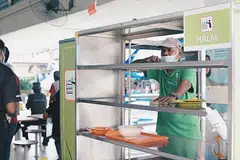 KERJA SUDAH BERUBAH: Sejak peraturan membersihkan meja kendiri itu berkuatkuasa pada 1 Jun lalu, Encik Abdul Ajis Marican tidak perlu pergi dari meja ke meja untuk membersihkan meja makan dan hanya membantu menghantar pinggan-mangkuk dan dulang ke gerai para penjaja. - Foto BH oleh HARITH MUSTAFFA