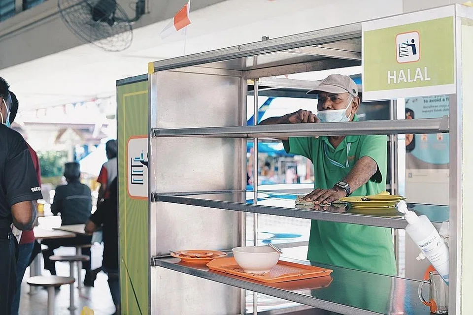 KERJA SUDAH BERUBAH: Sejak peraturan membersihkan meja kendiri itu berkuatkuasa pada 1 Jun lalu, Encik Abdul Ajis Marican tidak perlu pergi dari meja ke meja untuk membersihkan meja makan dan hanya membantu menghantar pinggan-mangkuk dan dulang ke gerai para penjaja. - Foto BH oleh HARITH MUSTAFFA