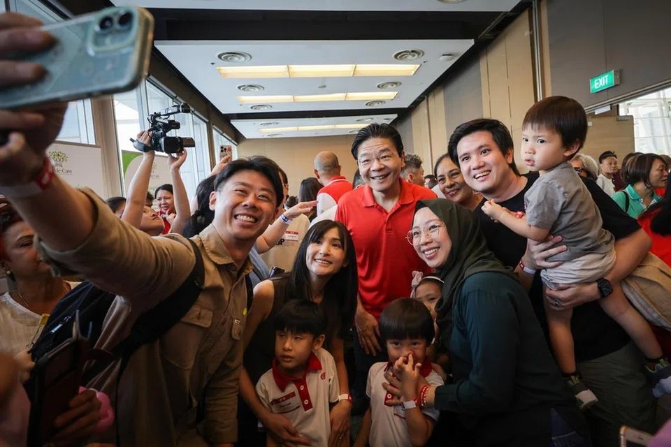 Perdana Menteri, Encik Lawrence Wong bergambar bersama para peserta Hari Keluarga Yayasan Masyarakat PAP (PCF) yang diadakan pada 13 Julai di Singapore Expo.