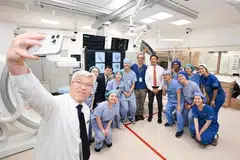 Dr Chia Ghim Song (kiri), Perunding Kanan Jabatan Neuroradiologi Hospital Besar Singapura (SGH), mengambil swafoto berkumpulan bersama Menteri Penyelaras bagi Dasar Sosial merangkap Menteri Kesihatan, Encik Ong Ye Kung (tengah, bertali leher), dan pasukan Suite Angiografi pada majlis perasmian bangunan Jabatan Kecemasan SGH dan Institut Sains Neuro Nasional (NNI) pada 30 Oktober.