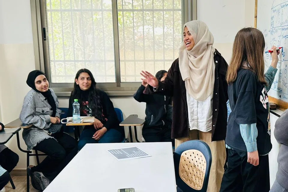 LIBATKAN PELAJAR: Cik Atikah melakukan kegiatan bersama pelajar semasa mengajar kelas bahasa Inggeris bersama kanak-kanak pelarian Palestin di Kem Pelarian Al-Fawwar, Hebron, Tebing Barat.