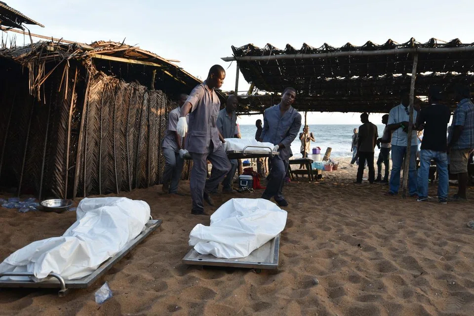 YANG TERBUNUH: Pekerja membawa keluar mayat mangsa kejadian serangan pengganas di Ivory Coast. -- Foto AFP