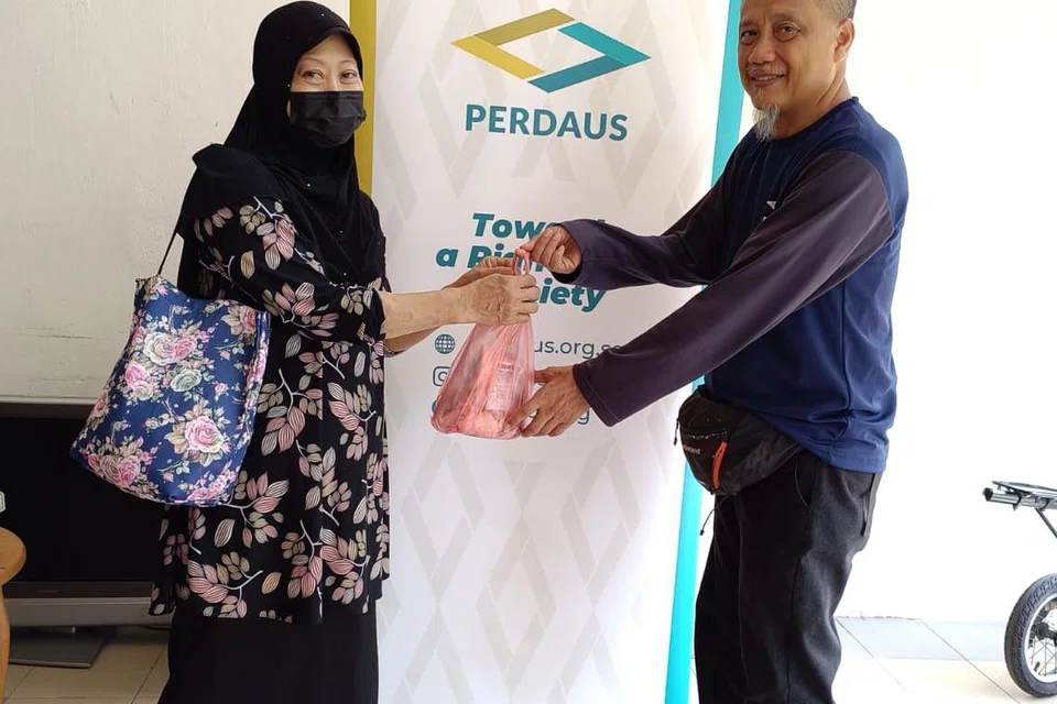 Pegawai Qurban Perdaus, Ustaz Raja Muzaffar Shah Raja Rosli, mengagihkan daging korban kepada golongan memerlukan di daerah estet perumahan Kampong Chai Chee pada tahun 2023 bagi Qurban Perdaus 2023.