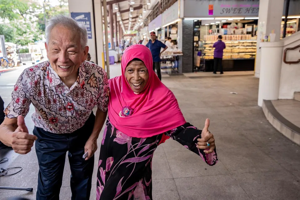 GURAU SENDA: Encik Ng Kok Song sempat bergurau senda dengan para pelanggan semasa lawatannya ke Pasar Geylang Serai.