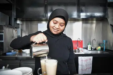 BERDIKARI DALAM BERTUGAS: Di bawah Program Persediaan Pekerjaan Dewasa di My Inspiring Journey (MIJ) Special Education Hub, Cik Siti Nur 'Ain berpeluang menjalani latihan bekerja di tempat kerja di Ashraf's Cafe dan ditawarkan pekerjaan sambilan tetap kemudian. - Foto BH oleh KUA CHEE SIONG