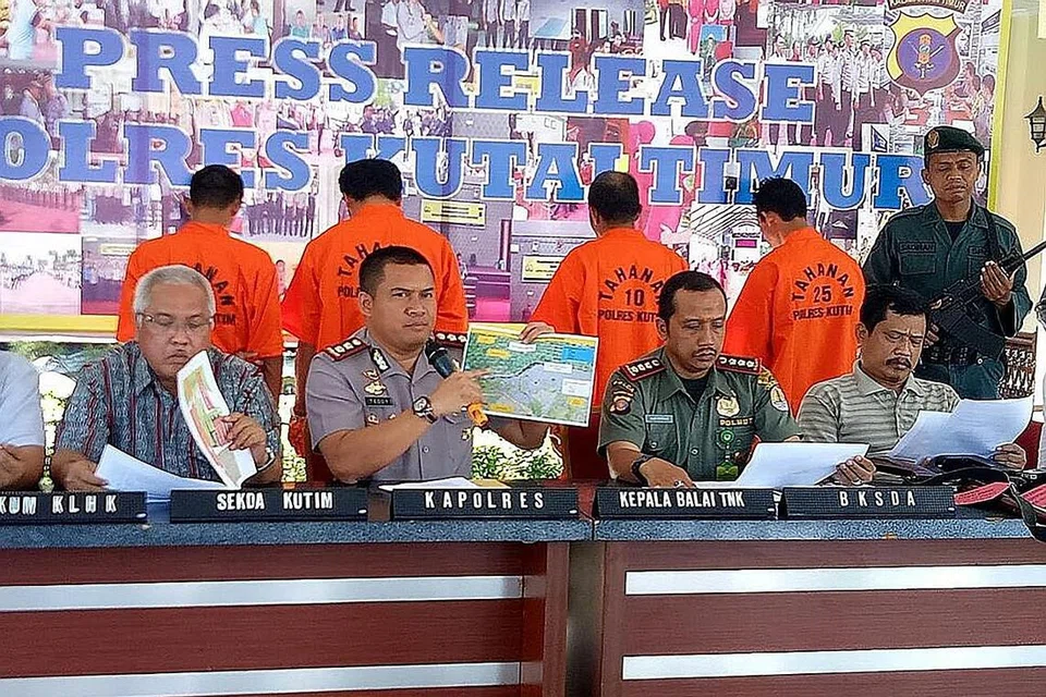 DEMI MELINDUNGI HAIWAN: Empat suspek (berbaju oren) pembunuhan seekor orang hutan yang ditemui mati dengan 130 tanda tembakan diketengahkan semasa satu sidang media polis di Kutai Timur, Kalimantan pada 18 Februari lalu. - Foto AFP