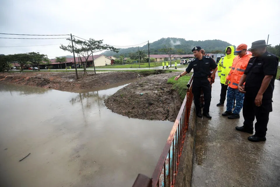 Ketua Polis Terengganu, Datuk Mohd Khairi Khairudin (kiri), meninjau keadaan paras air parit di kawasan Telok Kalong, Kemaman, pada 20 November.