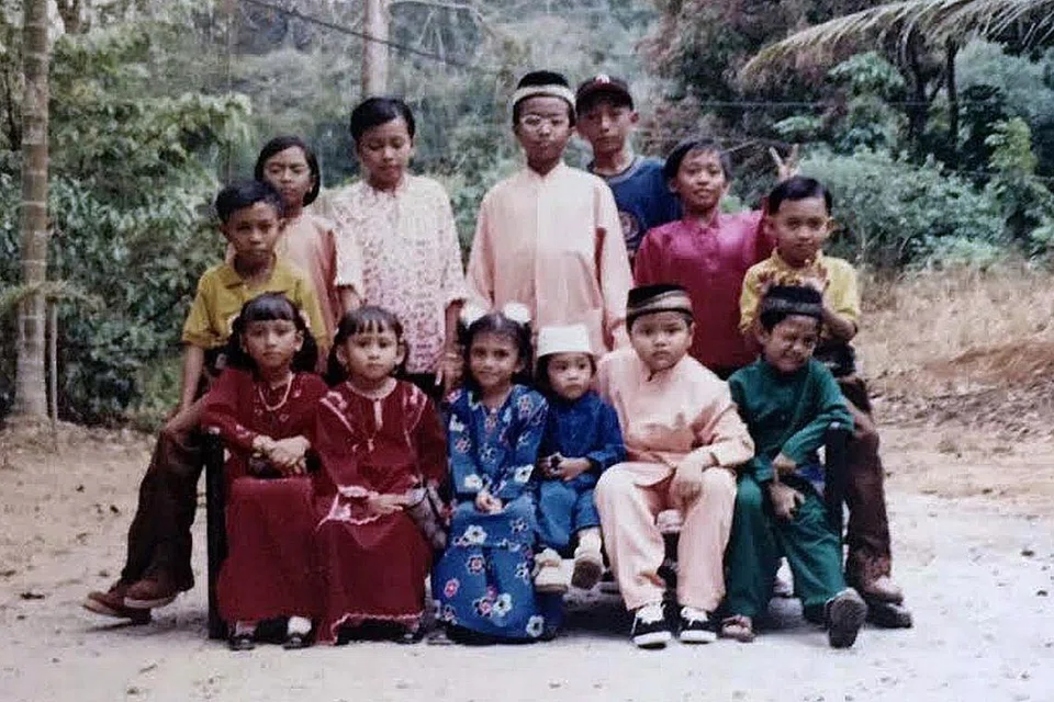 Cik Yusrina (berdiri, paling kiri) bersama saudara-maranya bergambar di kampung mereka di Pulau Ubin pada zaman 1990-an.
