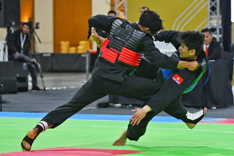  Ahmad Hanin Abdul Rahim (kiri) menjatuhkan lawannya dari Vietnam, Minh Triet Nguyen, dalam perlawanan kelas D putra (60-65kg) Sukan SEA 2025 pada 14 Disember di Dewan Impact Forum, Bangkok.
