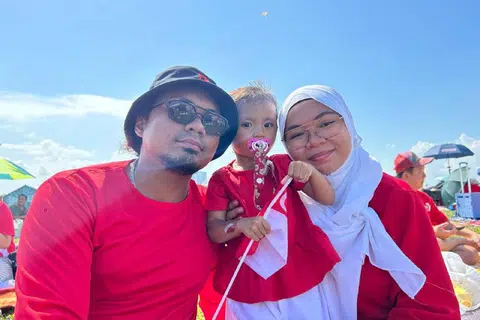 NIKMATI SUASANA SEKELUARGA: Encik Muhammad Haris Roslan dan isterinya Cik Nur Zuhairah Murad bersama puteri mereka berusia dua tahun, Nafiatul Hazimah, berada di Bendungan Marina bagi menikmati suasana NDP sejak 2 petang pada Rabu.
