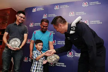 TERIMA PENGHARGAAN: (Dari kiri) Encik Yap, Encik Yusman, anaknya Mohd Ashqil dan Komander Transcom, AC Koh Wei Keong sewaktu majlis penghargaan semalam. - Foto BH oleh KELVIN CHNG
