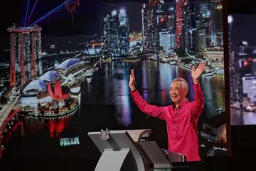 Perdana Menteri, Encik Lee Hsien Loong, melambai kepada hadirin dan penonton di penghujung Rapat Hari Kebangsaan (NDR) 2021. NDR merupakan masa Encik Lee membuat pengumuman penting termasuk dasar baru bagi negara. 