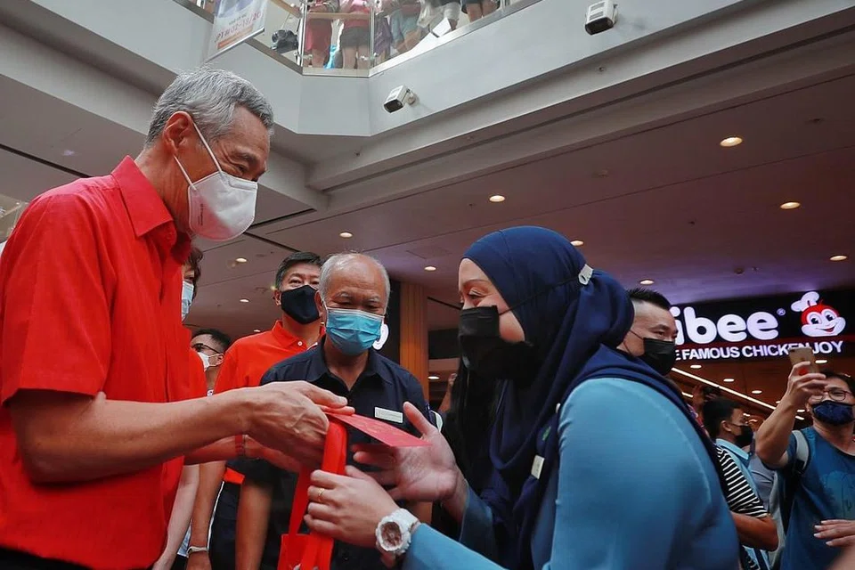 KONGSI KEMERIAHAN: Encik Lee turut menemui pekerja di pusat beli-belah Jurong Point seperti pekerja khidmat pelanggan, Cik Irnawati Rohen, yang menerima ang pao dan habuan Tahun Baru Cina. - Foto-foto BH oleh JASOH QUAH