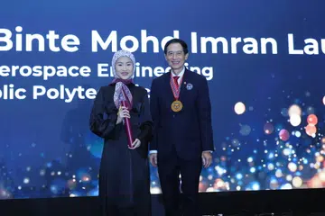 Cik Ayumi Erraziqa menerima Biasiswa IES-Mendaki daripada Presiden Institusi Jurutera Singapura (IES), Encik Er. Chan Ewe Jin, semasa Majlis Makan Malam Tahunan ke-59 IES, pada 3 November di Hotel Fairmont Singapore.