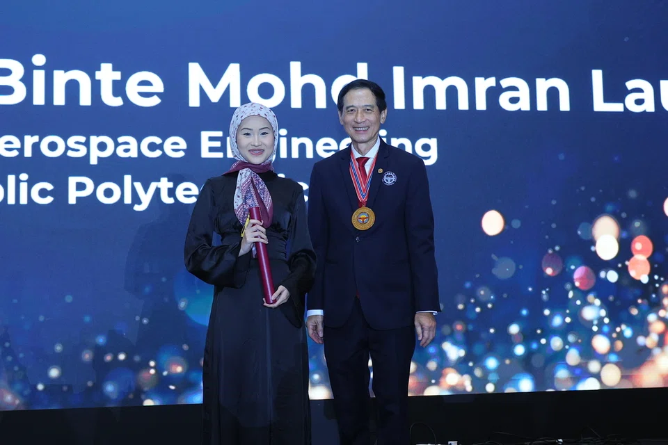 Cik Ayumi Erraziqa menerima Biasiswa IES-Mendaki daripada Presiden Institusi Jurutera Singapura (IES), Encik Er. Chan Ewe Jin, semasa Majlis Makan Malam Tahunan ke-59 IES, pada 3 November di Hotel Fairmont Singapore.