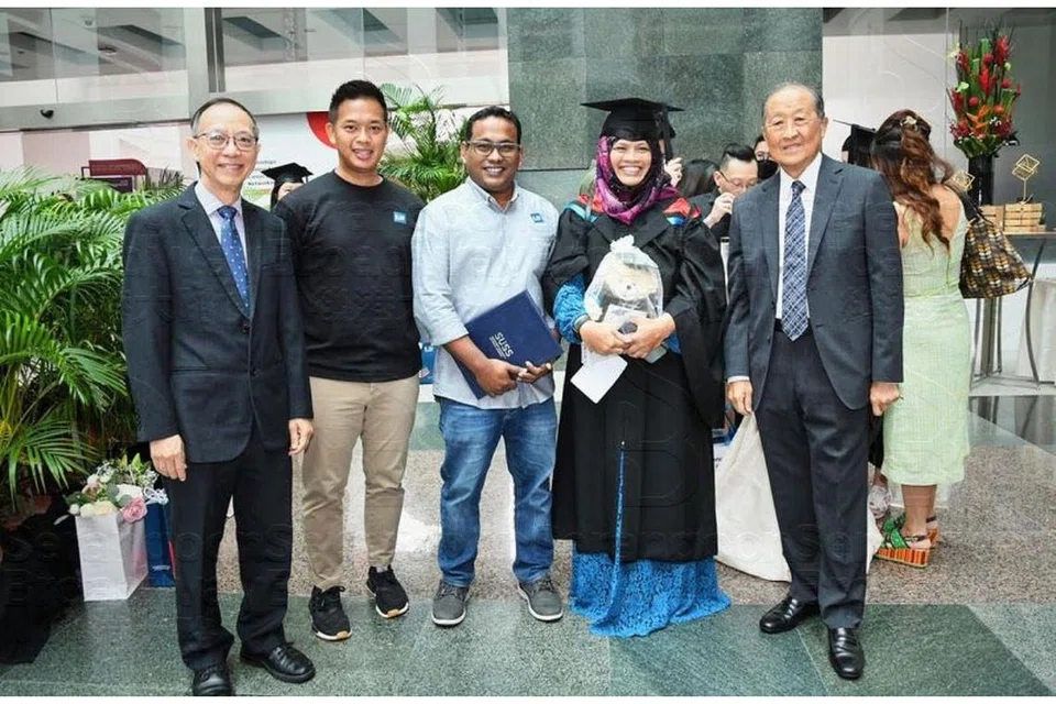 KEMANISAN BURU ILMU: Cik Rohani As'ad (dua dari kanan) mengecapi jaya menggenggam segulung ijazah Sarjana Muda Sains Dalam Perniagaan daripada Universiti Sains Kemasyarakatan Singapura (SUSS) baru-baru ini. Bersamanya (dari kiri) Presiden SUSS, Profesor Cheong Hee Kiat; adik Cik Rohani, Encik Muhammadf Farid; suaminya Encik Muhamed Sharif dan Canselor SUSS (kanan), Encik Stephen Lee. - Foto ihsan ROHANI AS'AD