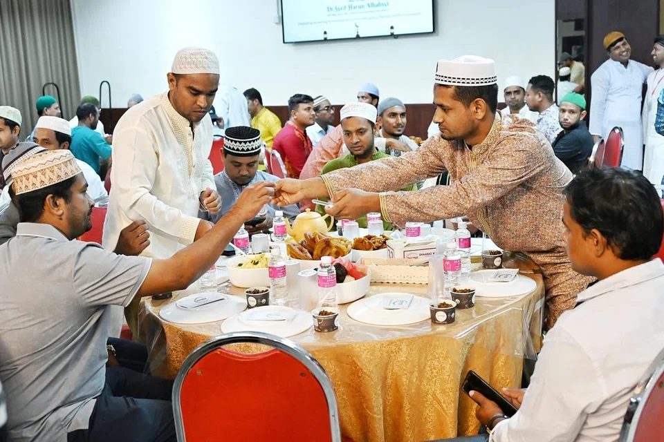 Pekerja migran bersama-sama berbuka puasa di satu majlis yang diadakan di Foo Chow Building di Tyrwhitt Road pada 1 Mac.