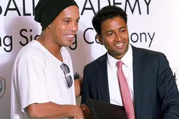 SALAM KERJASAMA: Pengerusi baru Tampines, Krishna Ramachandra (kanan), bersalaman dengan bintang bola sepak Brazil, Ronaldinho, semasa memeterai satu kerjasama yang akan menyaksikan bekas Pemain Terbaik Dunia itu melancarkan akademi bola sepaknya di sini. - Foto fail