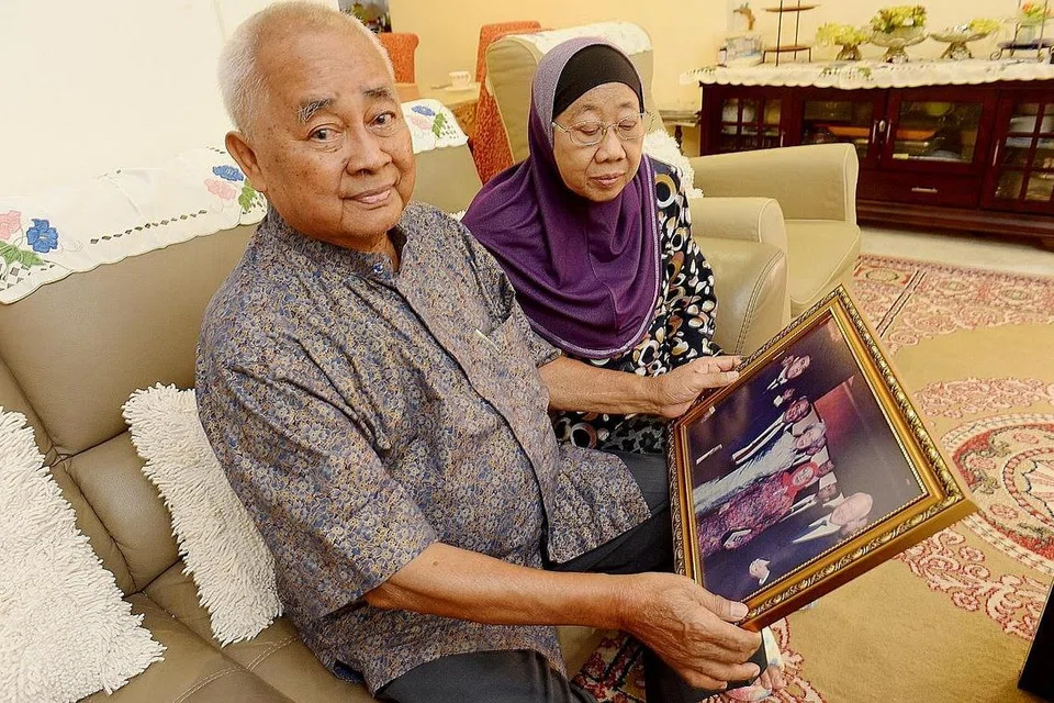 KENANGAN MANIS: Cikgu Amin dan isterinya, Cikgu Jamilah Ghazali, melihat foto mereka menghadiri majlis penyampaian ijazah anak mereka. - Foto fail BH