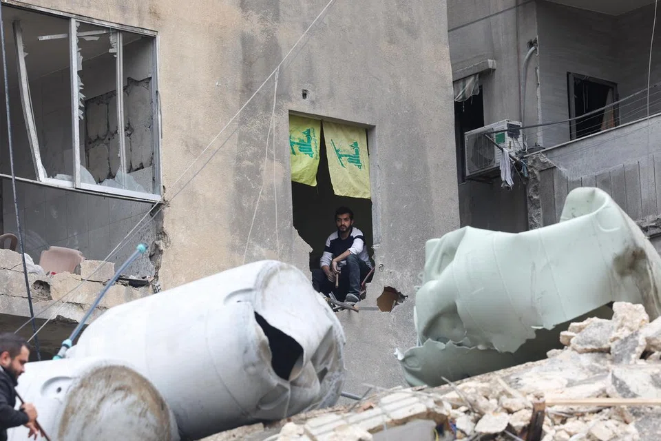 Seorang lelaki duduk di sebuah bangunan yang rosak di luar kawasan selatan Beirut.