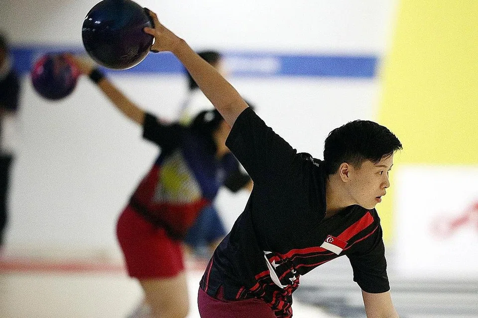 HARUMKAN NAMA NEGARA: Pemain catur Gong Qianyun dan pemain boling New Hui Fen (atas) menambah 'lombong' emas Singapura di hari ketiga persaingan Sukan SEA di Filipina. - Foto ZAOBAO