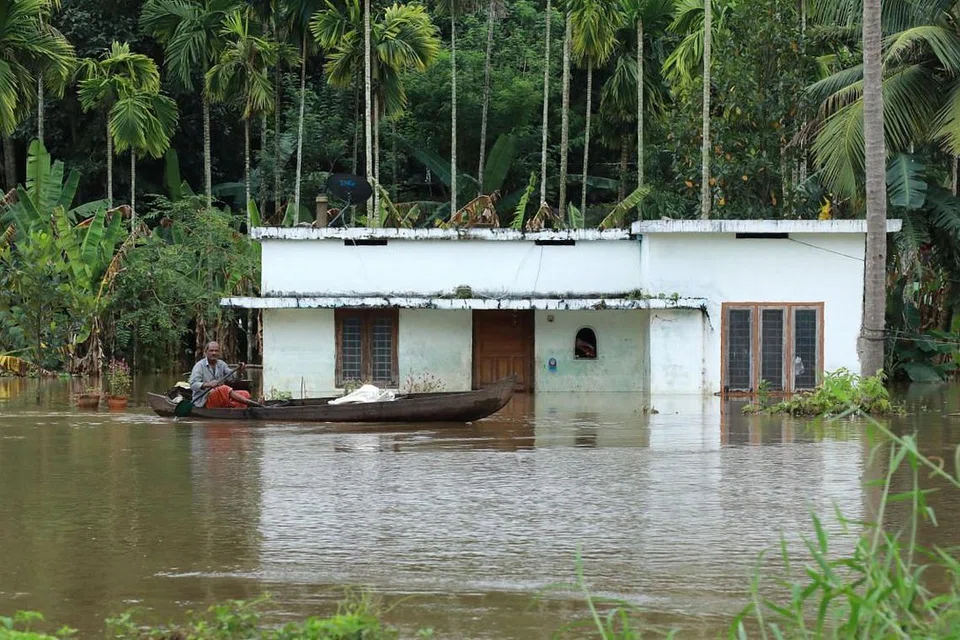 BANJIR TERBURUK DALAM 100 TAHUN: Seorang lagi berdayung mencari keselamatan sementara sebuah rumah hampir tenggelam sepenuhnya di daerah Ernakulam, Kochi, semasa negeri Kerala di India dilanda bah terburuknya dalam satu abad. - Foto fail AFP