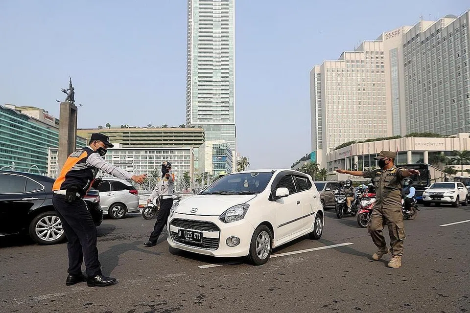 DITAHAN: Pegawai polis Indonesia menahan sebuah kereta setelah didapati pemandunya tidak memakai pelitup. - Foto EPA-EFE