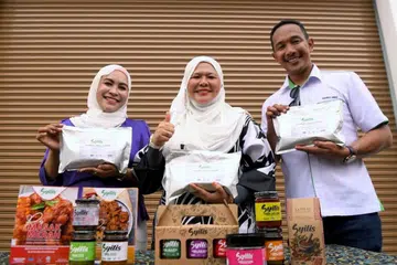 Pengerusi Jawatankuasa Pembangunan Wanita, Keluarga, Kebajikan Masyarakat, Pembangunan Usahawan dan Koperasi Perak, Datuk Salbiah Mohamed, (tengah) dan Ketua Pegawai Eksekutif Syilis Food Manufacturing Sdn Bhd, Encik Shahrol Annaz Abdul Nasir, (kanan) bergambar bersama produk keluaran Sylis semasa Majlis Pelepasan Produk Sambal Nasi Lemak Syilis ke Arab Saudi di Batu Gajah, pada 15 Julai.