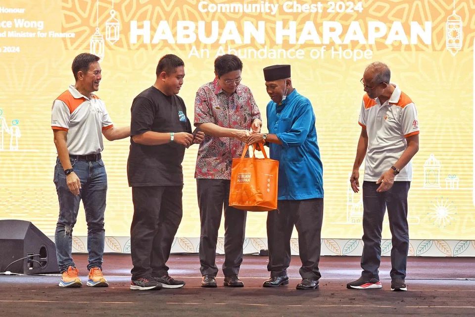 Timbalan Perdana Menteri, Encik Lawrence Wong (tengah), menyampaikan habuan kepada penerima yang merupakan wakil dari Wisma Geylang Serai (WGS) di acara Habuan Harapan Dana Masyarakat pada 13 Mac. Bersama beliau adalah Pengerusi Dana Masyarakat, Encik Chew Sutat (paling kiri), dan Menteri Pembangunan Sosial dan Keluarga yang juga Menteri Bertanggungjawab bagi Ehwal Masyarakat Islam, Encik Masagos Zulkifli Masagos Mohamad (paling kanan).