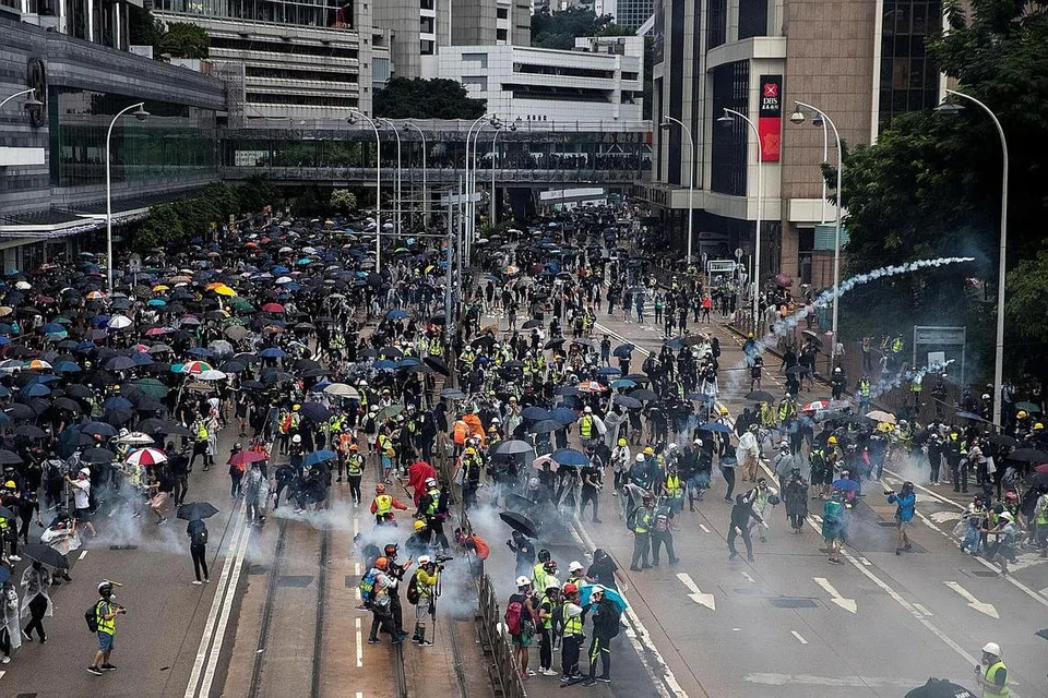 TUNJUK PERASAAN BESAR-BESARAN: Penunjuk perasaan antipemerintah lari daripada gas pemedih mata semasa protes di daerah Wan Chai di Hongkong kelmarin. - Foto REUTERS 