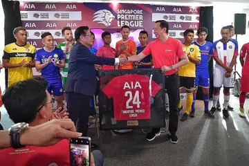 PERJANJIAN BARU: Encik Lim Kia Tong (depan, kiri) dan Encik Patrick Teow berjabat tangan selepas menandatangani perjanjian penajaan baru bagi musim Liga Perdana Singapura selama dua tahun. - Foto BH oleh DESMOND WEE