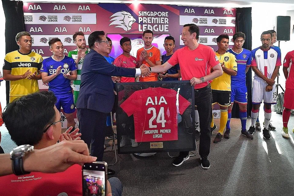 PERJANJIAN BARU: Encik Lim Kia Tong (depan, kiri) dan Encik Patrick Teow berjabat tangan selepas menandatangani perjanjian penajaan baru bagi musim Liga Perdana Singapura selama dua tahun. - Foto BH oleh DESMOND WEE