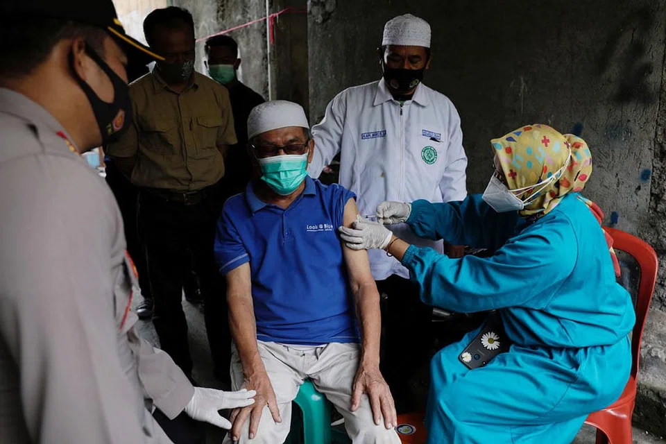 DARI RUMAH KE RUMAH: Encik Jeje Jaenudin, 68 tahun, menerima suntikan dos pertama vaksin Sinovac di luar rumahnya bagi memudahkan penduduk di Cianjur, Jawa Barat. - Foto REUTERS