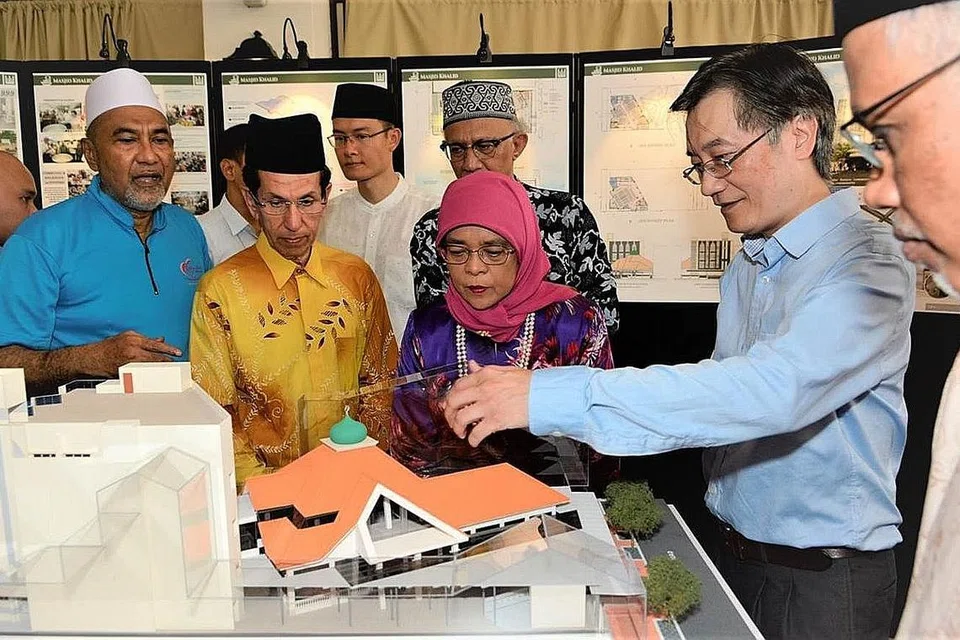 DENGAR TAKLIMAT: Puan Halimah (tiga dari kanan) mendengar taklimat mengenai kerja naik taraf Masjid Khalid oleh pakar seni bina Alfred Chua (dua dari kanan). Bersamanya ialah (dari kanan) Encik Masagos; Encik Abdullah; Encik Esa; Haji Alami; dan pengerusi Masjid Khalid, Encik Allaudin Mohamed. - Foto MUIS