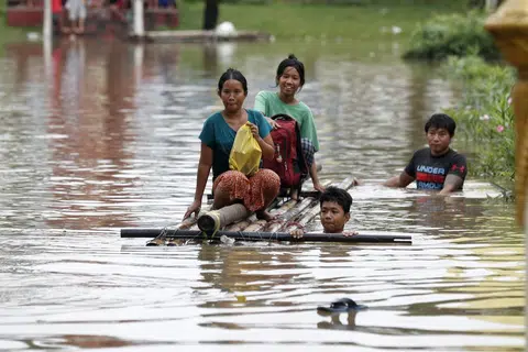 Para penduduk mengharungi air banjir dengan rakit di Taungoo, bahagian Bago, Myanmar, pada 16 September akibat hujan lebat ekoran Taufan Yagi, menyebabkan banjir teruk di beberapa wilayah di negara itu.