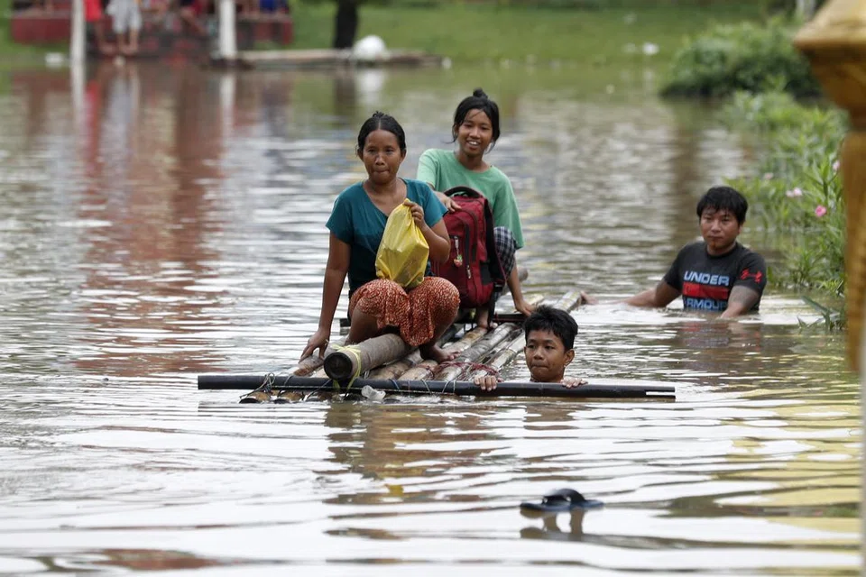 Para penduduk mengharungi air banjir dengan rakit di Taungoo, bahagian Bago, Myanmar, pada 16 September akibat hujan lebat ekoran Taufan Yagi, menyebabkan banjir teruk di beberapa wilayah di negara itu.