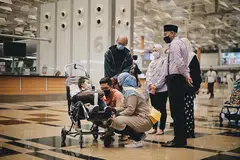 HULUR BANTUAN: Aryan bersama ibu bapanya dan beberapa kakitangan Persatuan Ain, termasuk Ketua Pegawai Eksekutif, Encik Md Yusof Ismail (kanan), di Terminal 3 sebelum keluarga itu berlepas ke New York untuk mendapatkan rawatan khusus. - Foto BH oleh HARITH MUSTAFFA