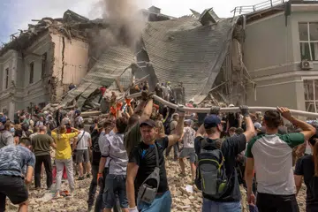 Para sukarelawan membantu pegawai penyelamat membersihkan runtuhan bangunan yang musnah di Hospital Kanak-Kanak Ohmatdyt ekoran serangan peluru berpandu Russia ke atas ibu kota Ukraine, Kyiv pada 8 Julai.