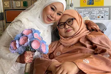SEMANGAT IBU: Cik Aqilah Faaiqah Haji Shamsuri (kiri) bernikah di Hospital Besar Singapura, dengan kehadiran keluarga terdekat termasuk ibunya yang meninggal dunia seminggu kemudian.