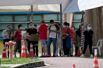 JALANI UJIAN COVID: Beberapa orang dilihat beratur untuk jalani ujian swab di di bekas bangunan Sekolah Rendah Coral di Pasir Ris Street 51. - Foto BH oleh LIM YAOHUI