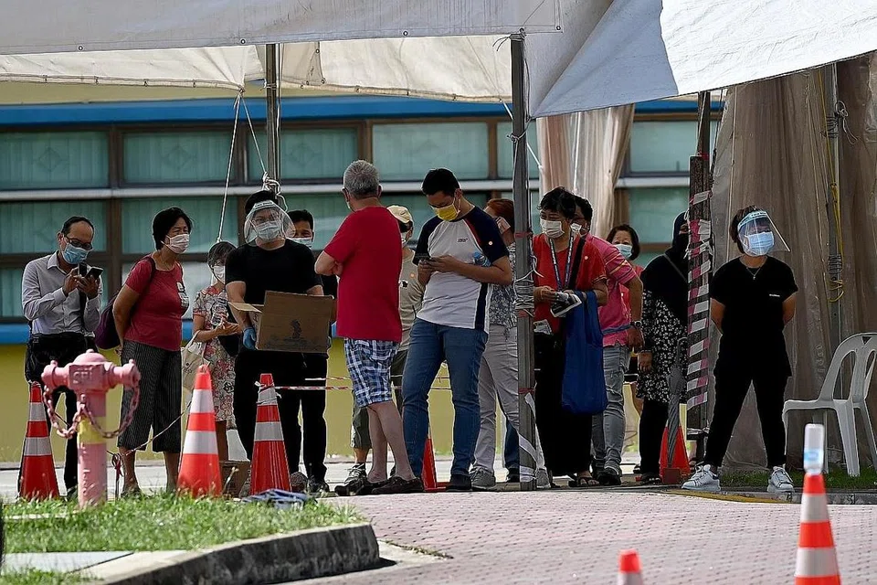 JALANI UJIAN COVID: Beberapa orang dilihat beratur untuk jalani ujian swab di di bekas bangunan Sekolah Rendah Coral di Pasir Ris Street 51. - Foto BH oleh LIM YAOHUI