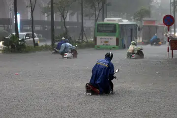 Orang ramai meredah banjir sambil menolak motosikal mereka di sebuah jalan yang ditenggelami air di Hanoi, Vietnam, pada 30 September 2025. Taufan Bualoi telah meragut sekurang-kurangnya 19 nyawa, mencederakan puluhan orang dan menyebabkan beberapa lagi hilang sejak ia melanda kawasan utara-tengah Vietnam, menurut media negara.
